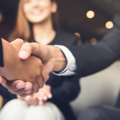 Businessmen making handshake with his partner in cafe - business etiquette, congratulation, merger and acquisition concepts